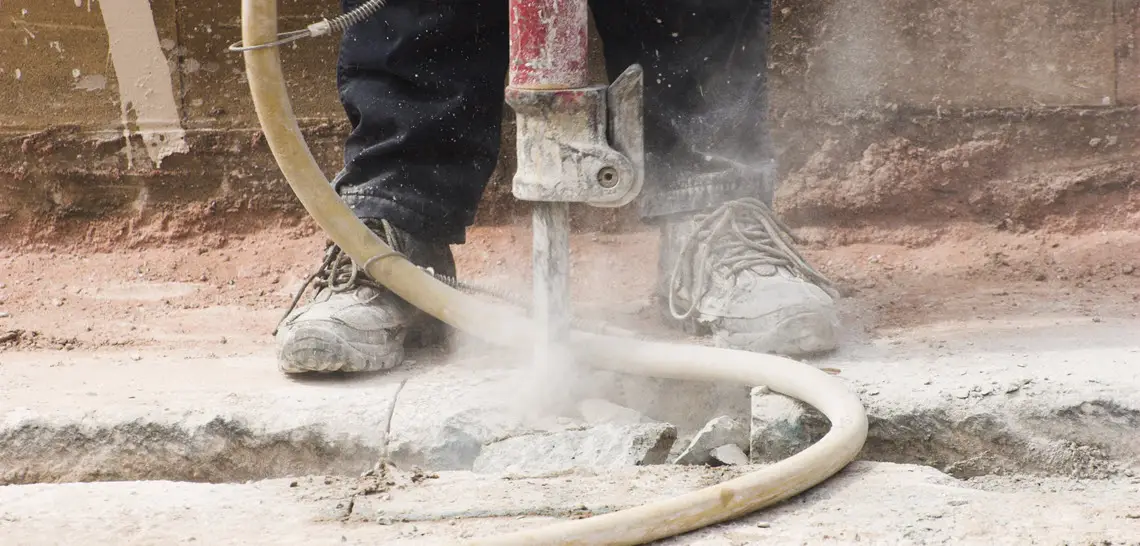 Man and jackhammer causing silica dust